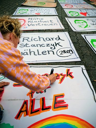 Taibe Qorri beim Malen von Plakaten