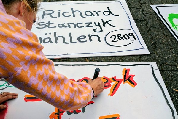 Taibe Qorri beim Malen von Plakaten