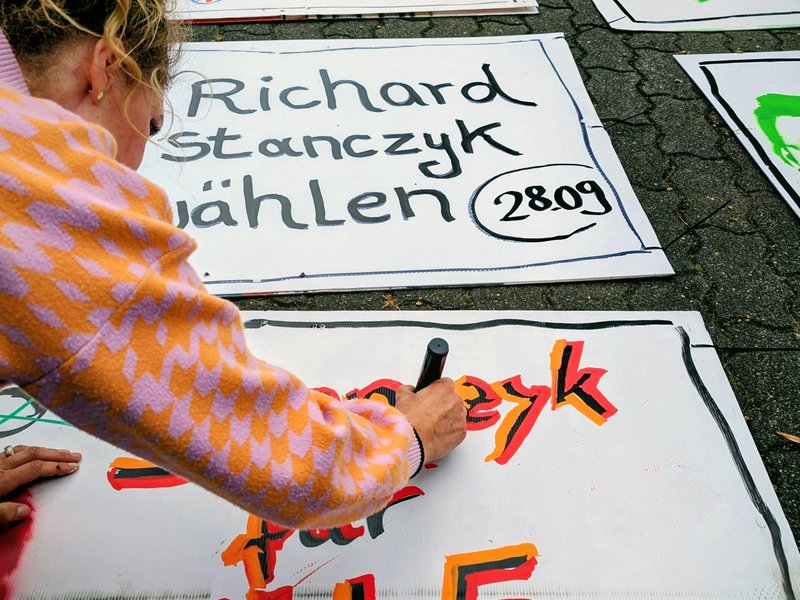 Taibe Qorri beim Malen von Plakaten